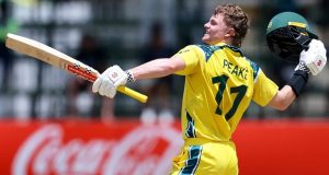 Oliver Peake holding cricket bat and helmet celebrating